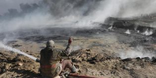 Workers battle to cap burning oil wells in Iraq, risk flames and mines